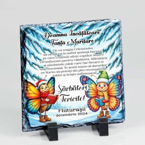 aceasta ardezie cadou invatatoare pentru clasafluturasilor este decorata cu un peisaj de iarna si 2 fluturasi veseli cu caciuli de Mos Craciun, fiecare avand cate o carte in mana.