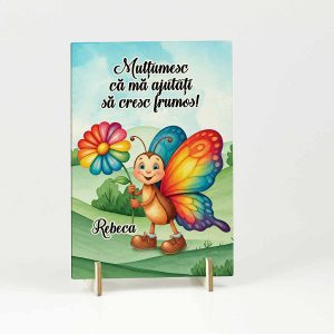 Decoratiune din lemn pentru educatoare sau invatatoare de la clasa fluturasilor. Decoratiunea din lemn are un fluturas colorat in nuante vesele care tine o floare in mana.