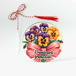 Imagine cu un martisor din lemn tip brosa cu panselute colorate legate cu o funda mare de culoare roz prafuit. Martisorul este personalizat cu mesajul PRimavara frumoasa!